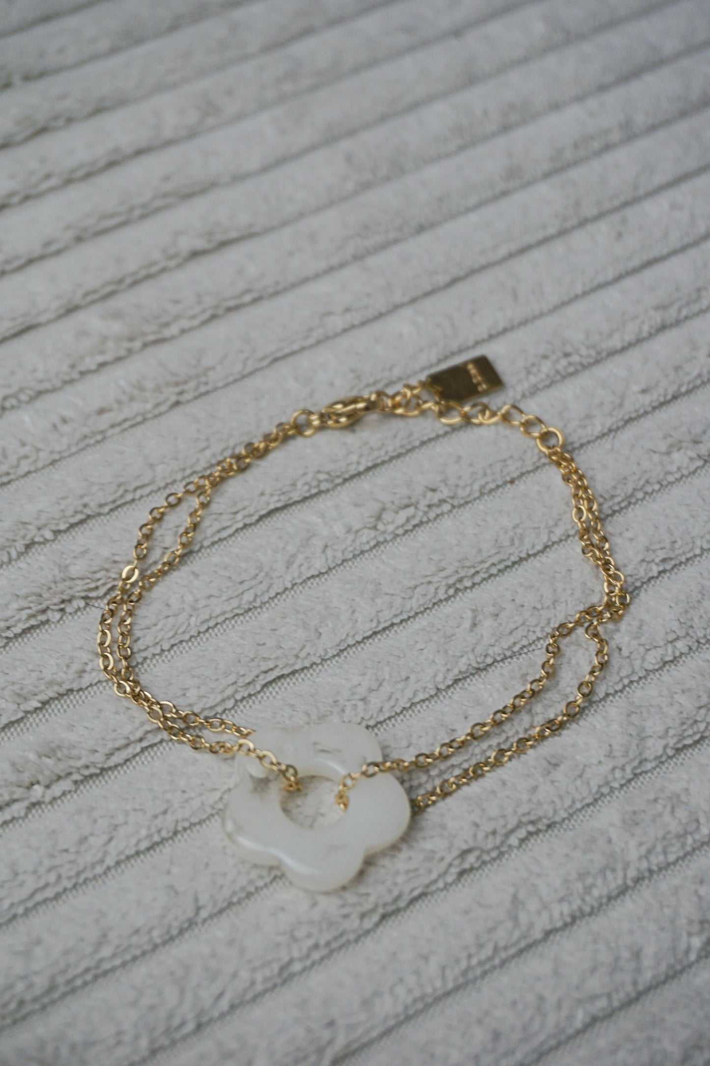Bracelet doré anneau fleur blanche