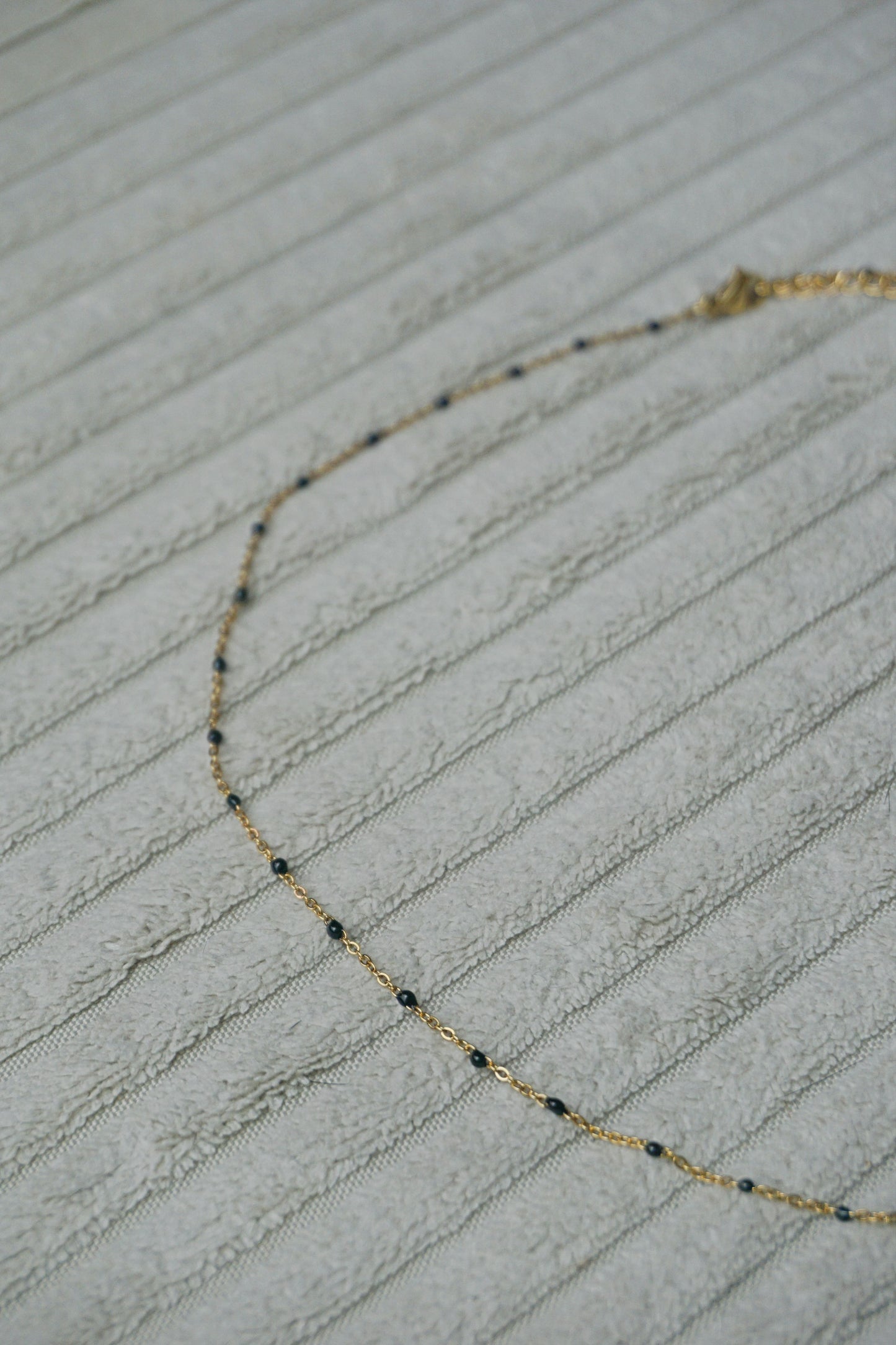 Collier fin doré perles noires