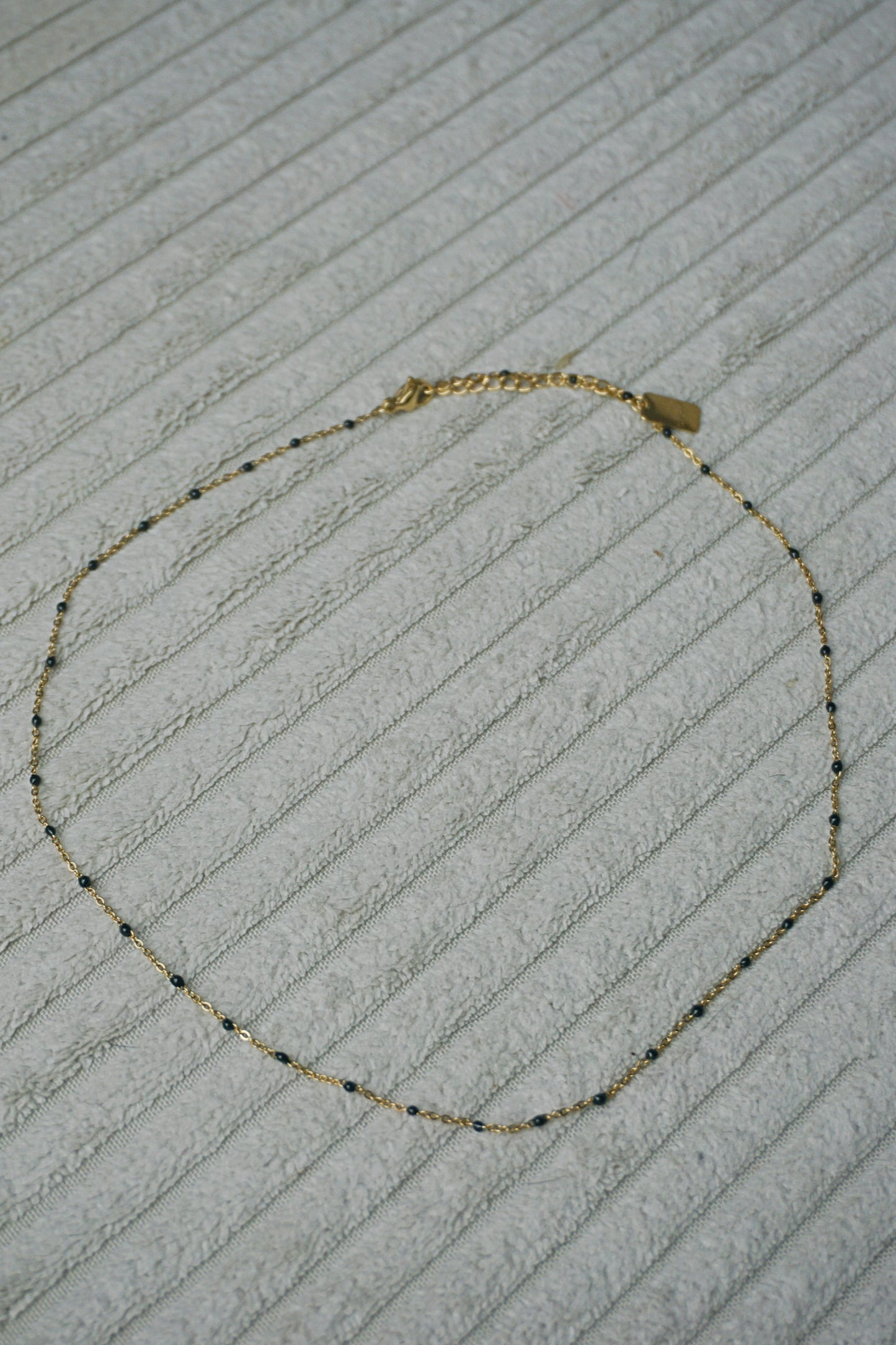 Collier fin doré perles noires