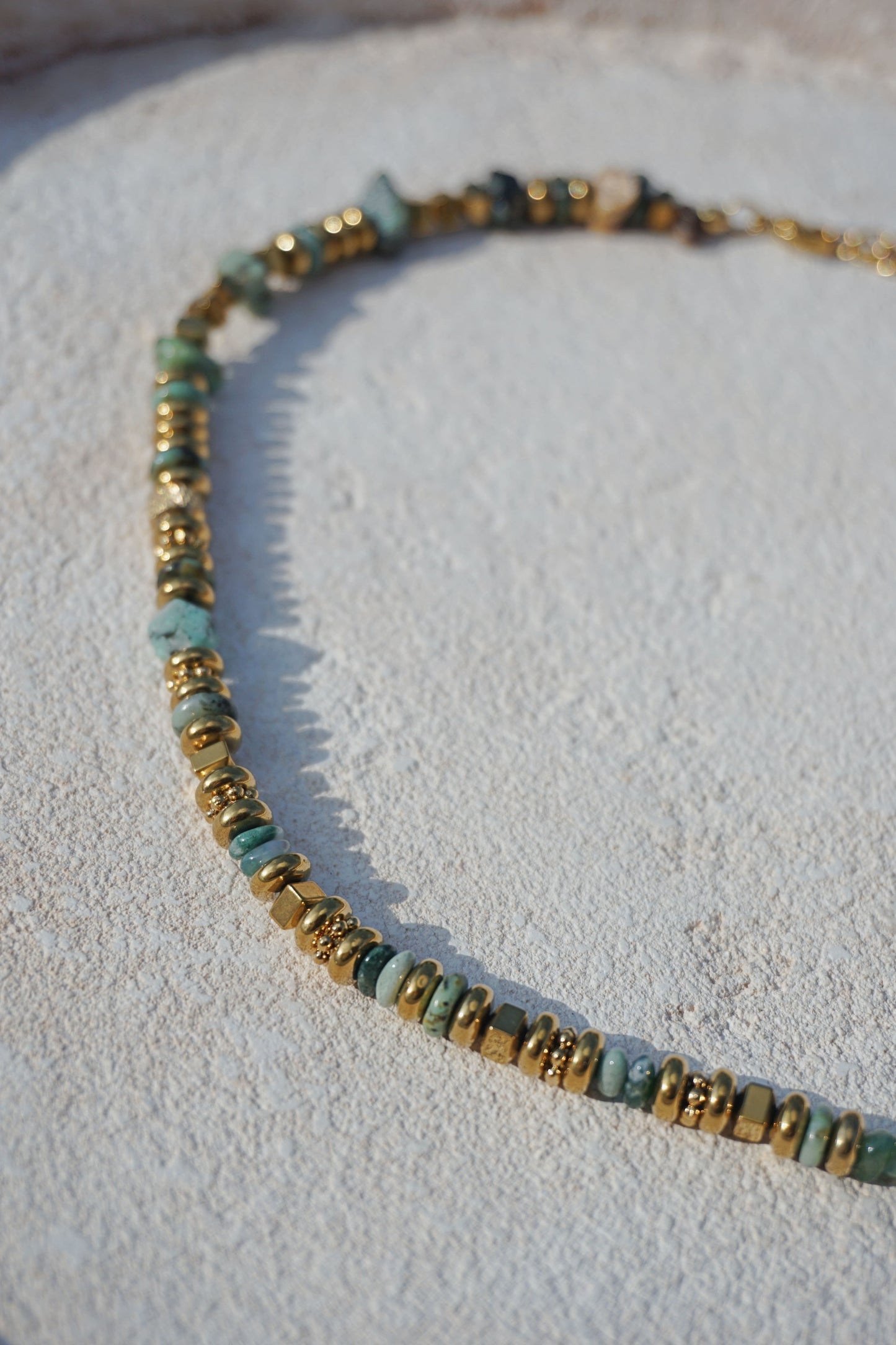 Collier doré avec pierres vertes