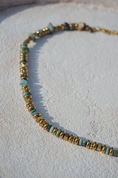 Collier doré avec pierres vertes
