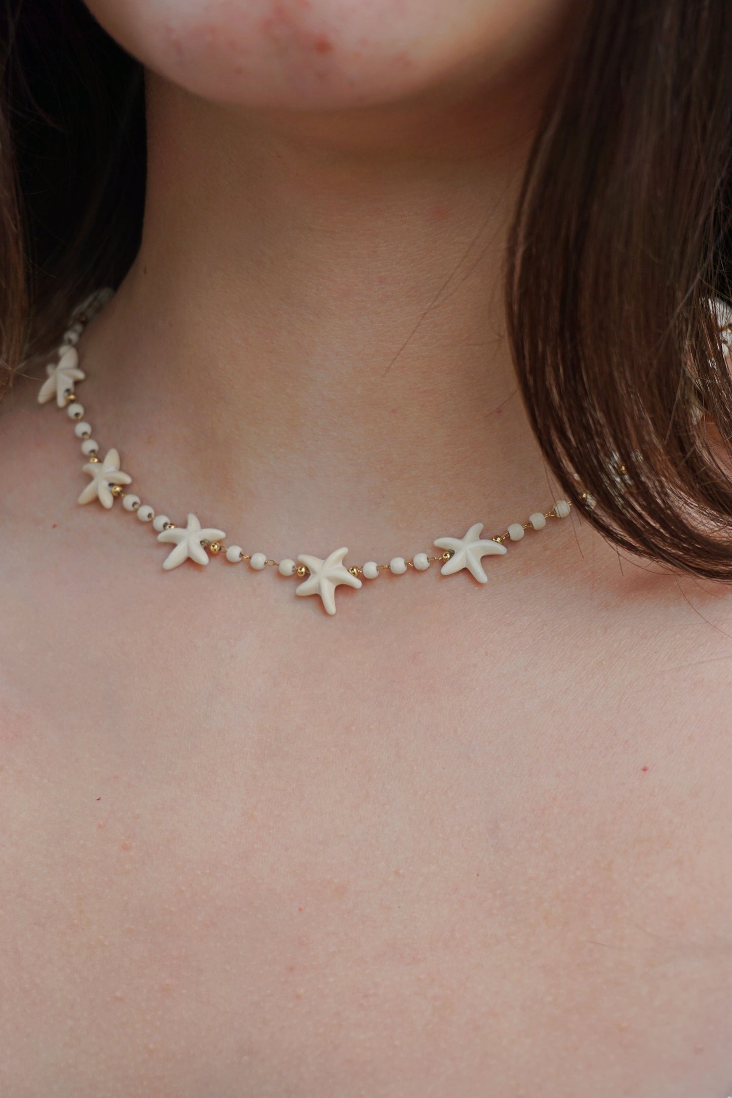 Collier doré et étoiles de mer écru