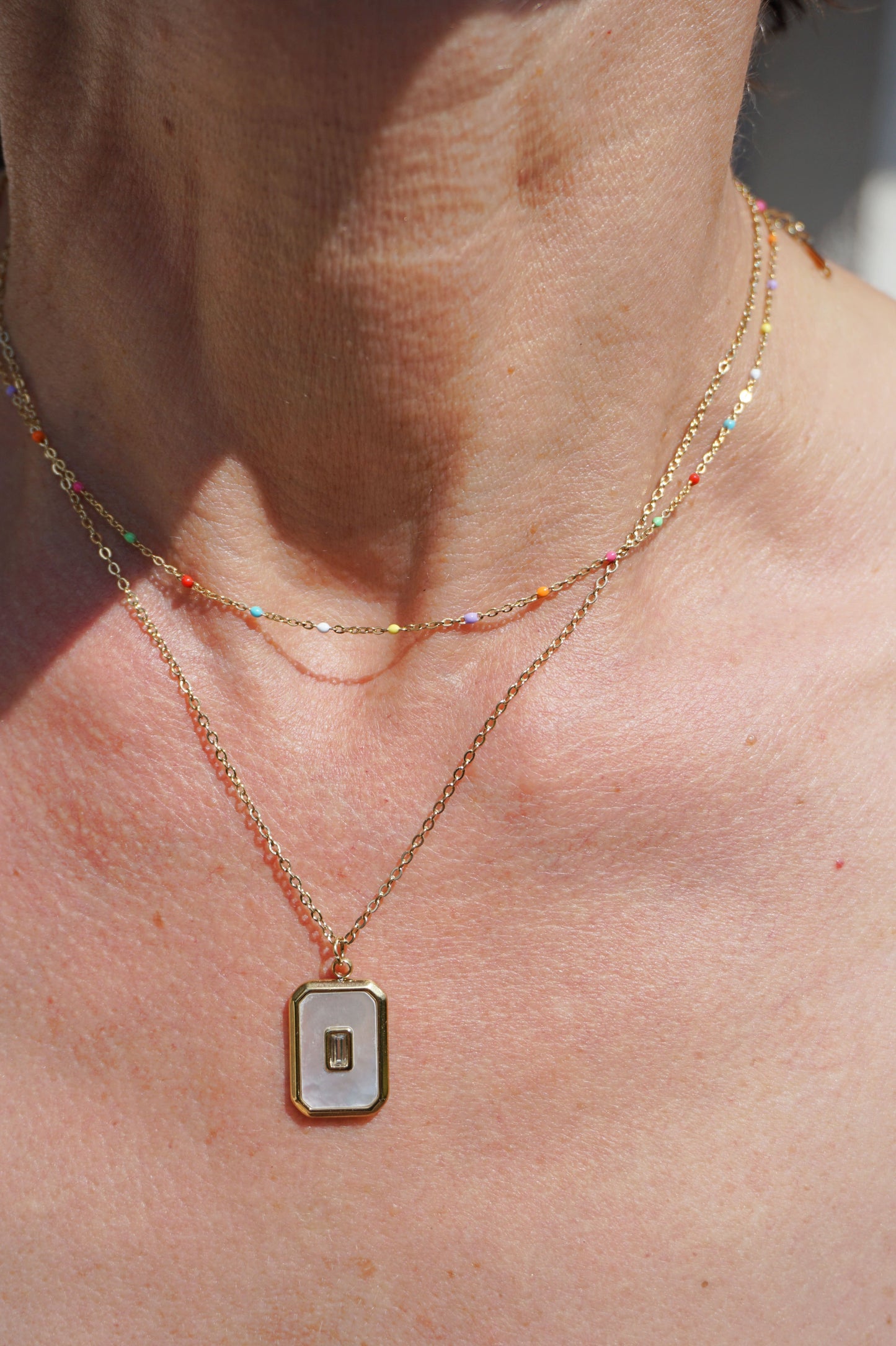 Collier doré pendentif blanc