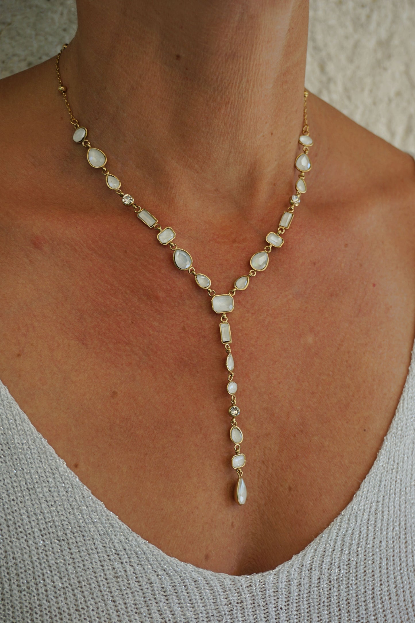 Collier doré tombant pierres blanches