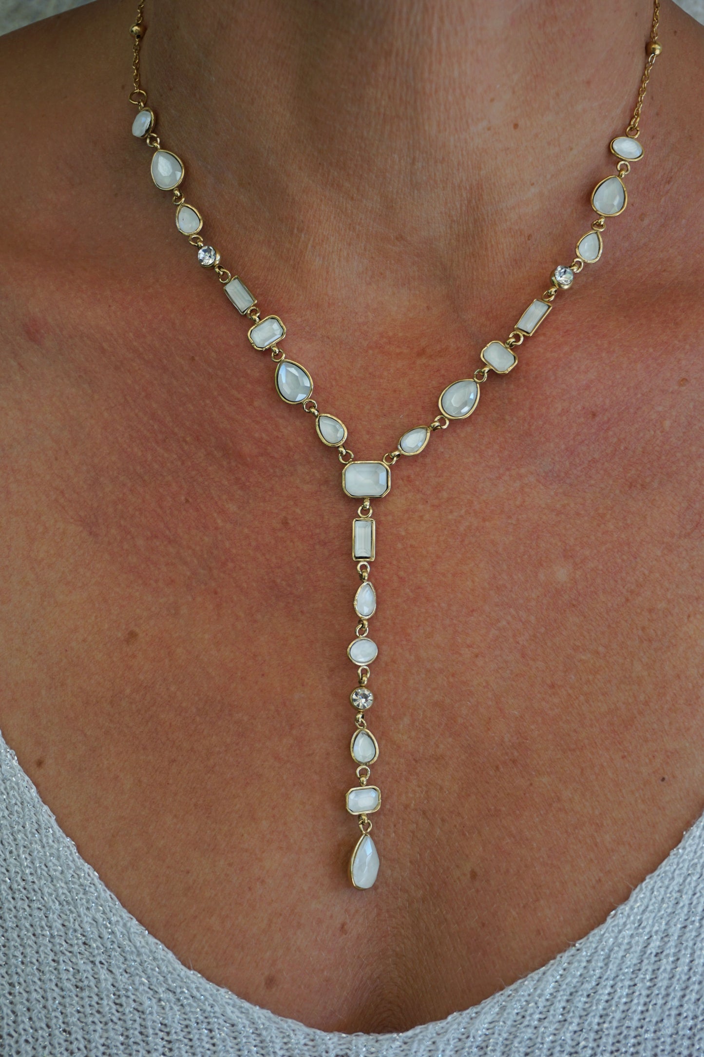 Collier doré tombant pierres blanches