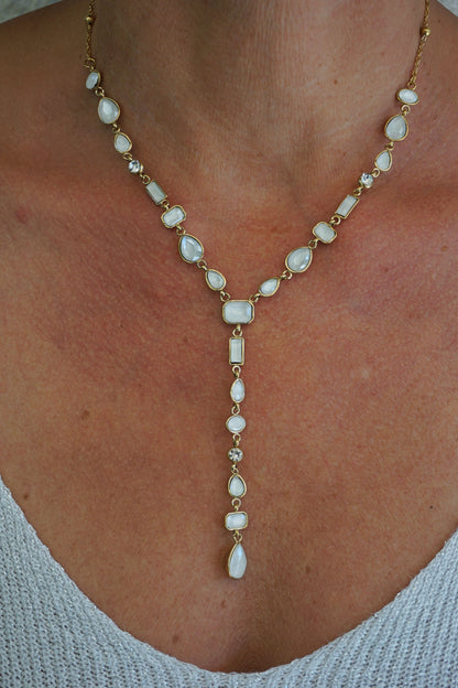 Collier doré tombant pierres blanches