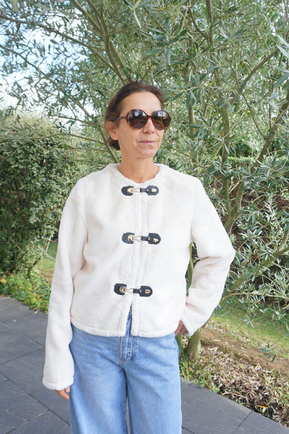 Veste à poils blancs et fermoirs dorés