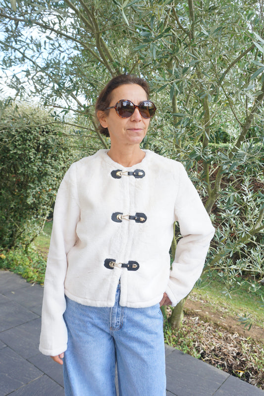 Veste à poils blancs et fermoirs dorés