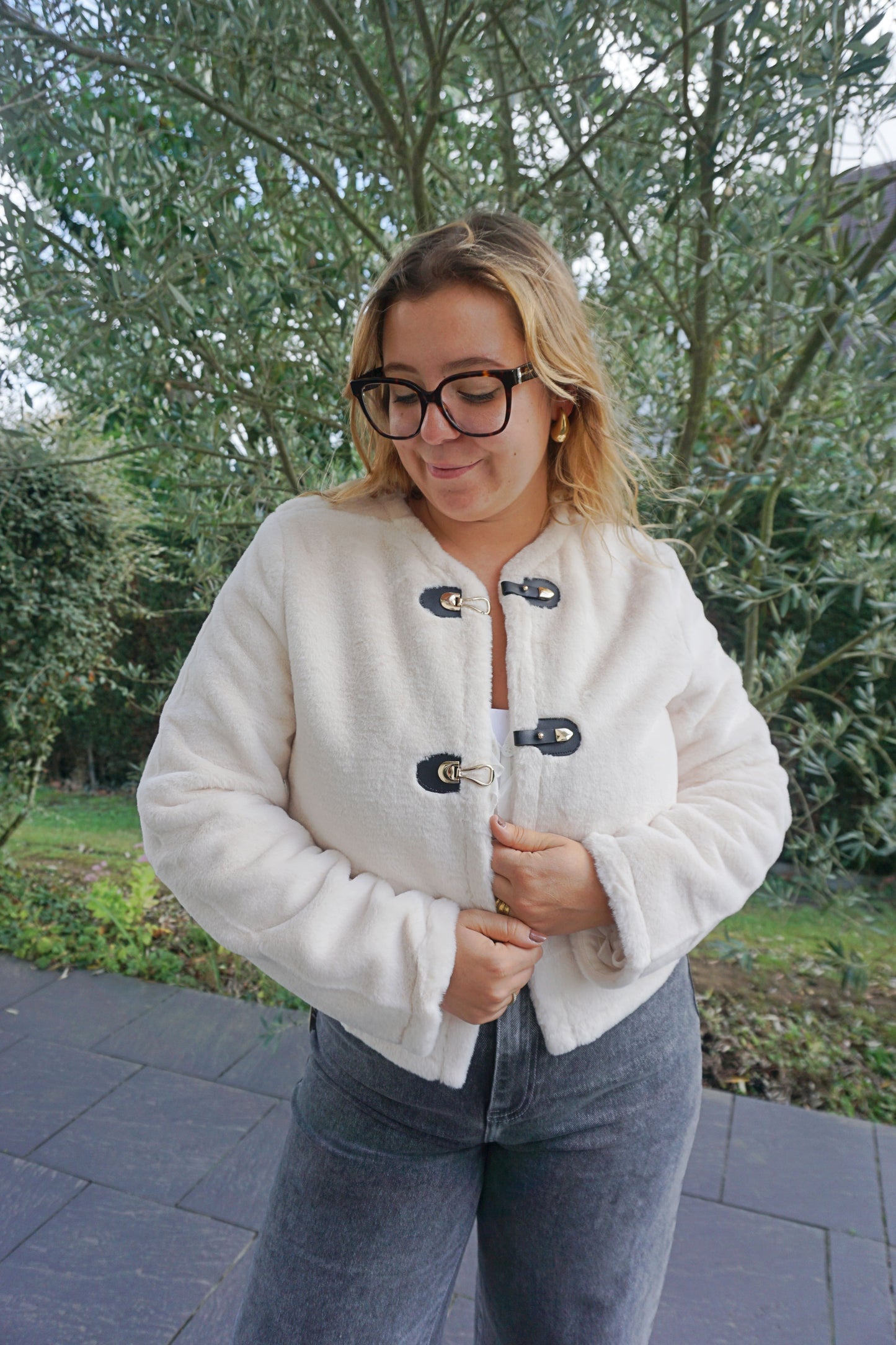 Veste à poils blancs et fermoirs dorés