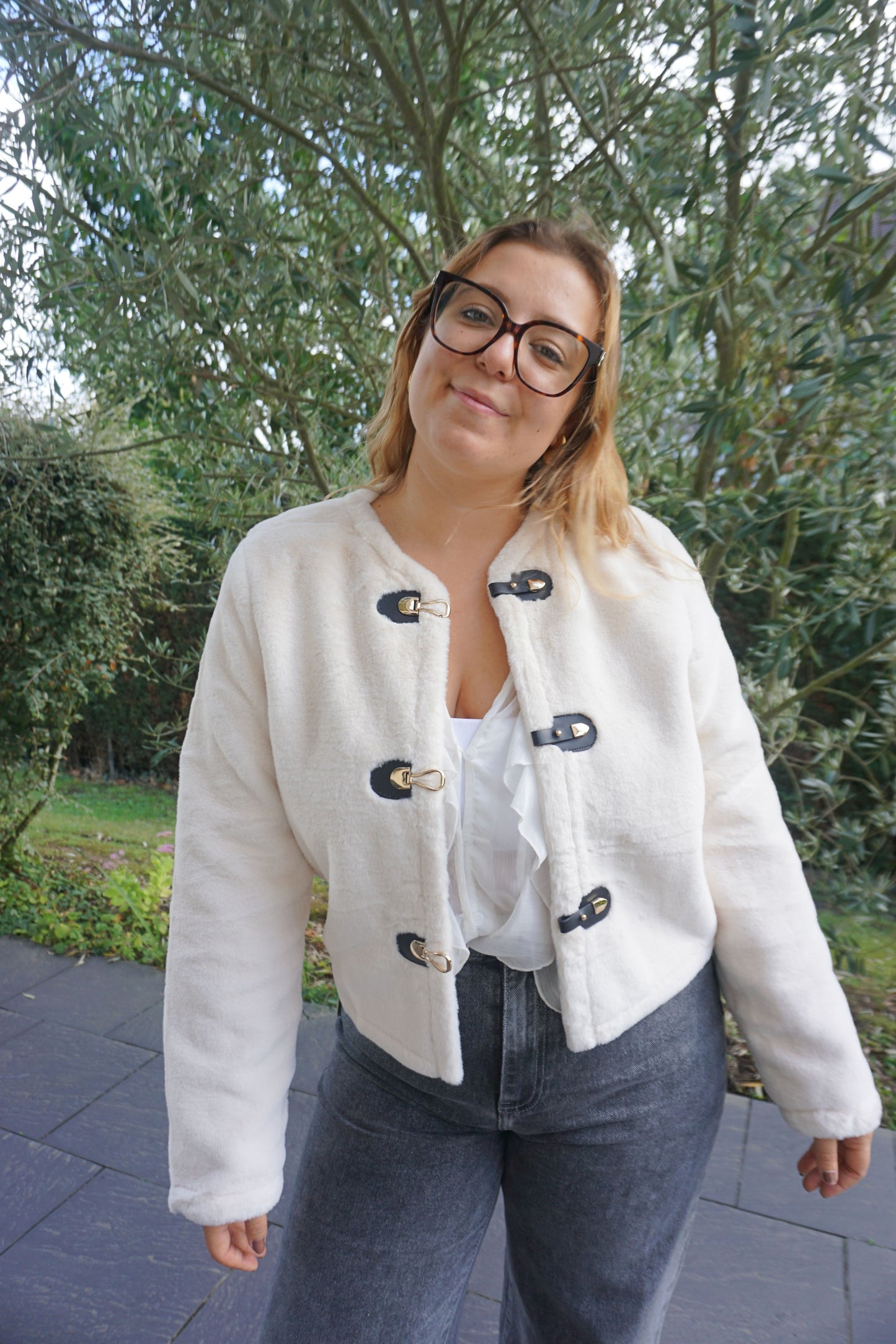 Veste à poils blancs et fermoirs dorés